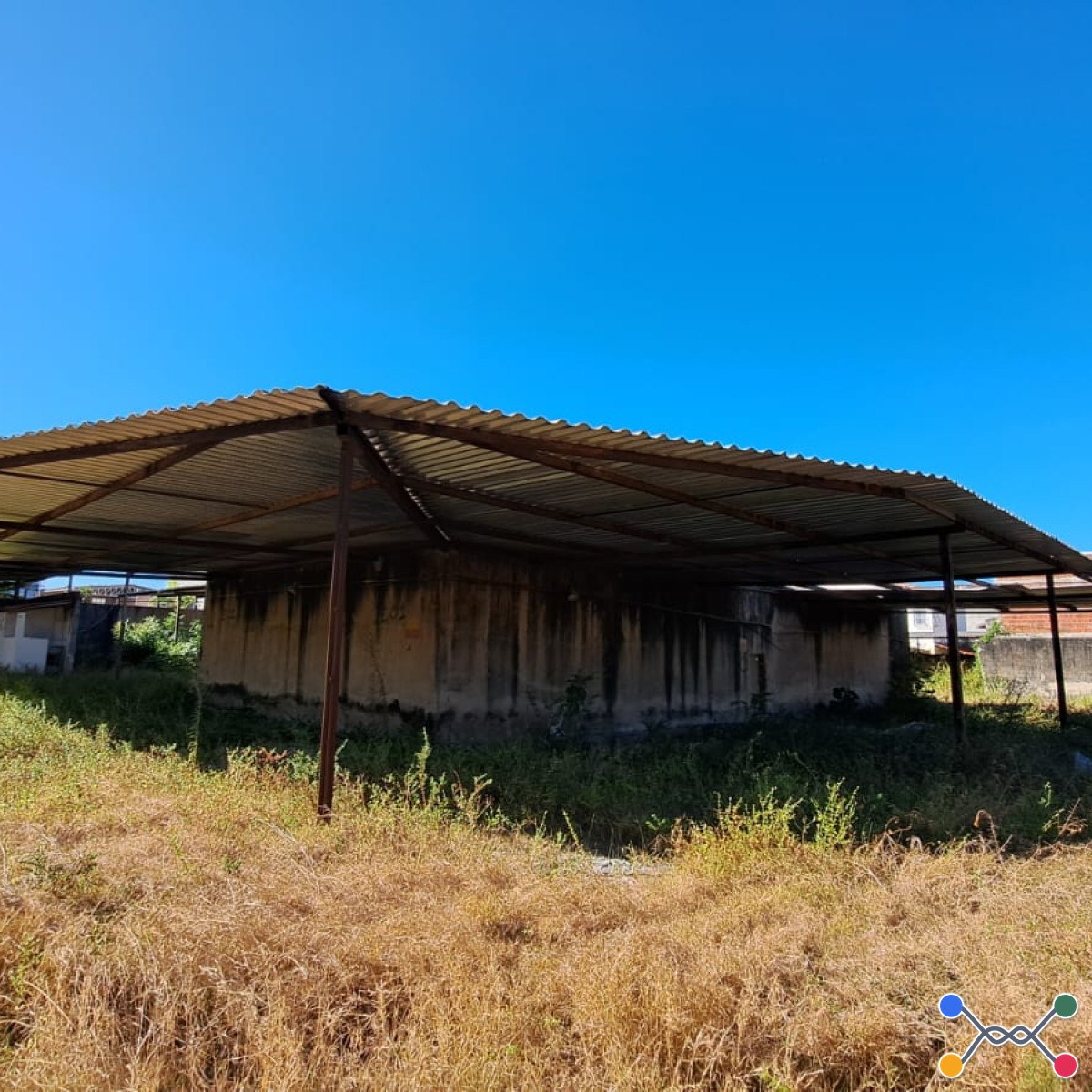 Lote 004 - Galpão em formato de L, com estrutura metálica e cobertura em telhas de alumínio, faltando algumas telhas (área total aproximada de 444,00 m²).