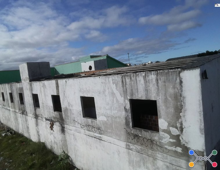Um terreno com um prédio de alvenaria construído sobre ele, contendo 16 unidades habitacionais